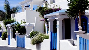 A white building with blue accents, including gates and door frames.