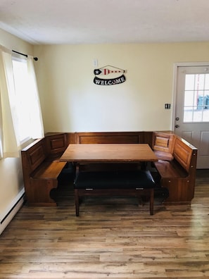 A room with a wooden bench table, a welcome sign, and a door. - Lakefront Reteat with boats and fire pit.  (Tobyhanna)