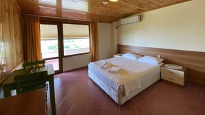 A room with a wooden ceiling, a bed with white linens, a nightstand, and a window with curtains. - Saygin Otel (Kandira)