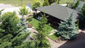 An aerial view of a building with a covered patio area, surrounded by trees and a grassy field. - Saygin Otel (Kandira)