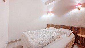 Ein Schlafzimmer mit einem Bett, zwei Nachttischlampen und einem hölzernen Kopfteil.