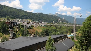Ein Bergdorf mit traditionellen Häusern, einer Brücke und einer Seilbahn.