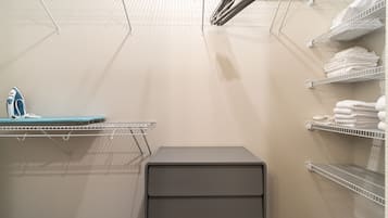 Un espace buanderie équipé d’étagères pour suspendre les vêtements, d’un étendoir et d’un meuble de rangement.