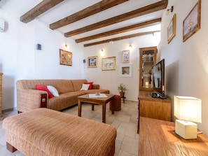 Relax in this inviting living room with a comfortable sofa, wooden coffee table, and potted plant.