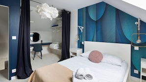 A modern hotel room with a bed, a desk, and a bathroom. - Jad'Or - Jolie Duplex avec parking privé (Nantes)