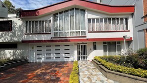 A two-story house with a garage, a driveway, and a stone pathway leading to the entrance.