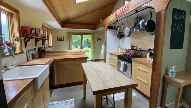 A spacious kitchen with wooden cabinets, a central island, and a skylight. - Charming & cozy in-town retreat in the heart of New Buffalo (New Buffalo)