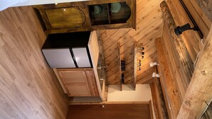 Une cuisine avec des meubles de rangement en bois, un plan de travail et un luminaire suspendu.