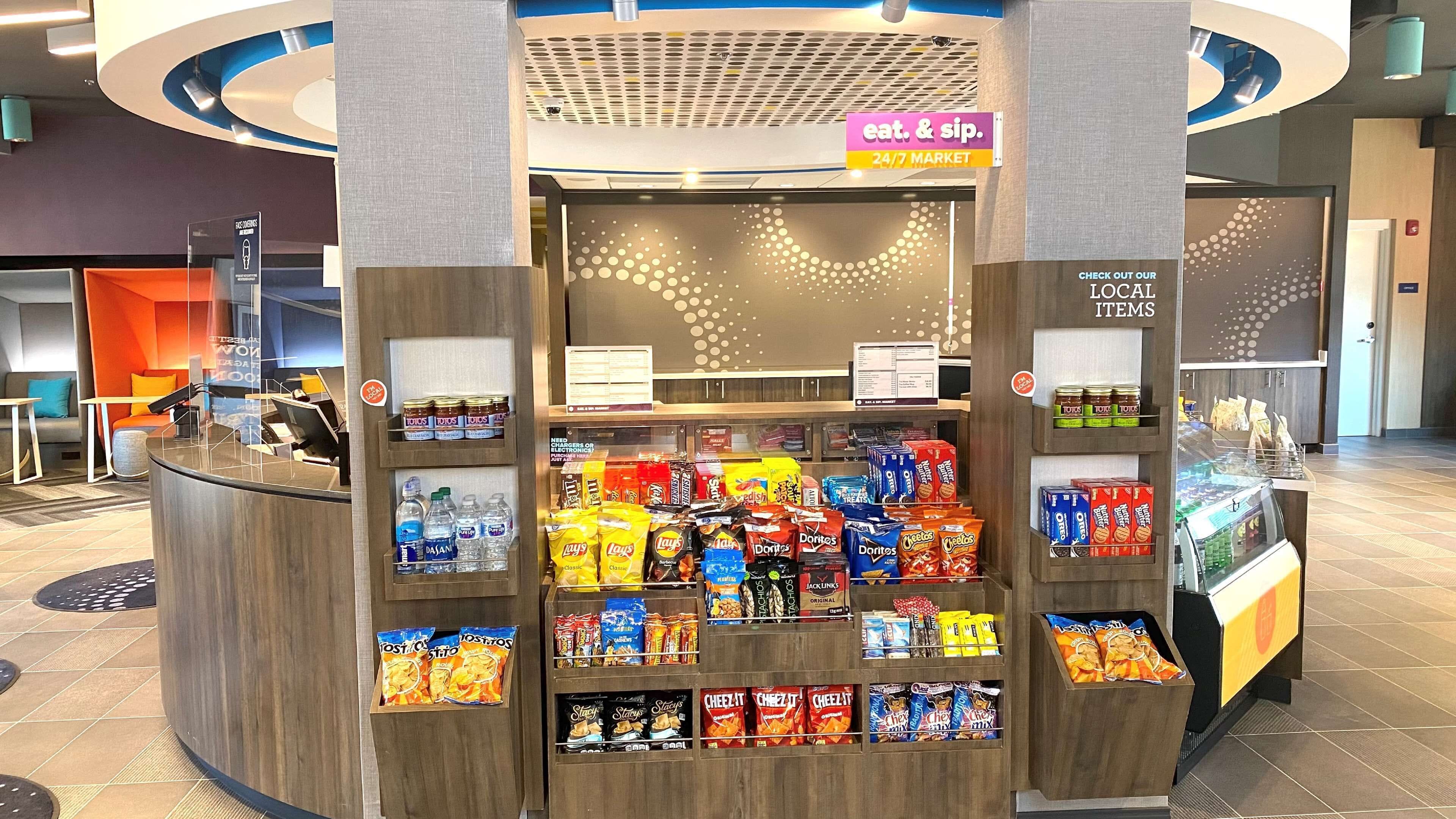 Un quiosco de aperitivos con una variedad de papas fritas y botanas, incluyendo Doritos, Lay's y Cheez-It.