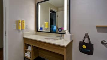 A bathroom with a sink, mirror, and toiletries.
