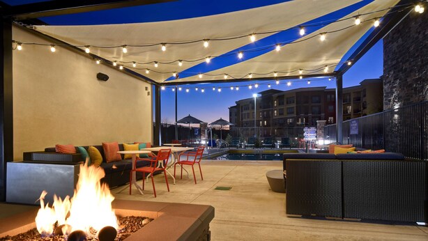 An outdoor patio area with a fire feature, seating, and string lights. - Tru By Hilton Rockwall Dallas, TX (Rockwall)