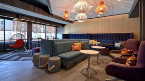 A modern lounge area with a sofa, armchairs, ottomans, and hanging pendant lights. - Tru By Hilton Rockwall Dallas, TX (Rockwall)