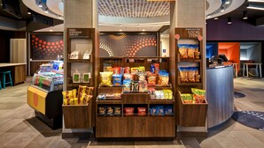 A snack kiosk with a variety of chips and beverages, a 24/7 market sign, and a counter for inquiries. - Tru By Hilton Rockwall Dallas, TX (Rockwall)