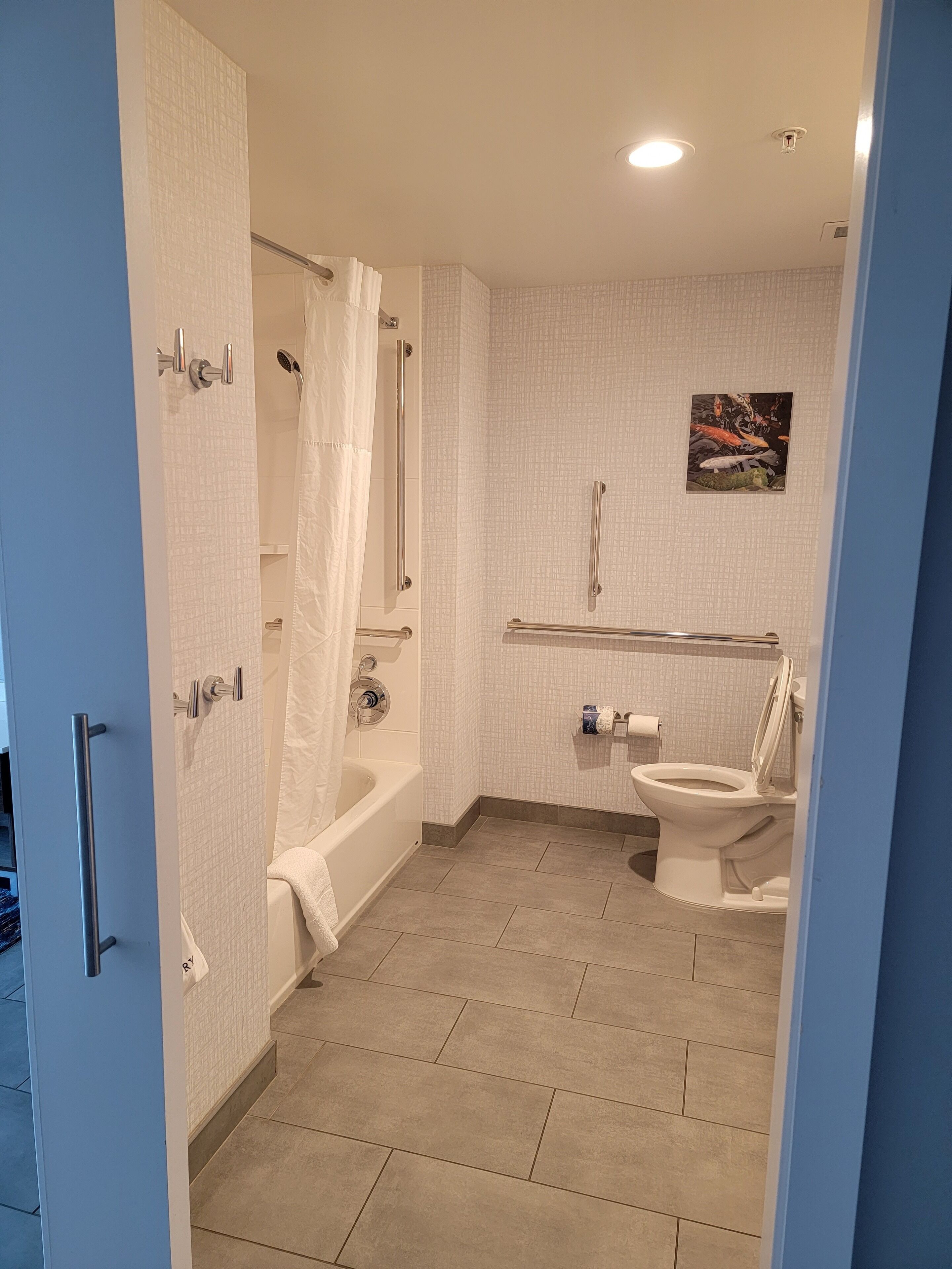 A bathroom with a bathtub, toilet, and shower.