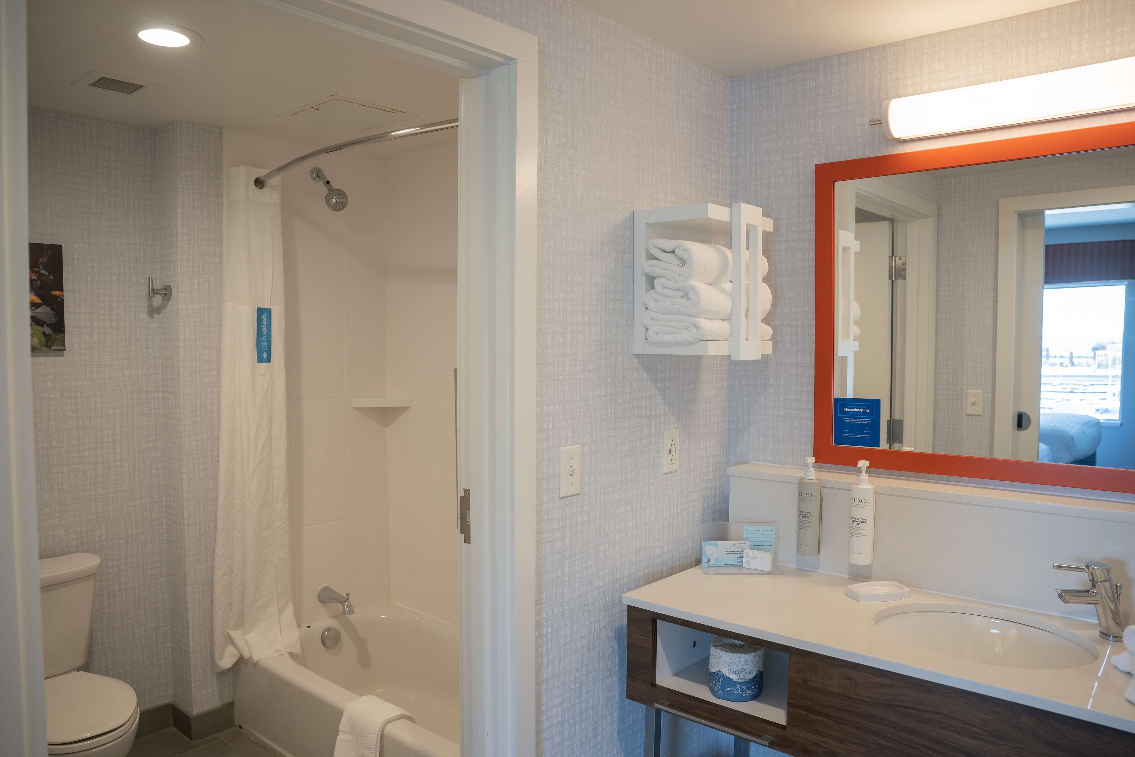A bathroom with a shower, toilet, and sink.