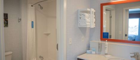 A bathroom with a shower, toilet, and sink.