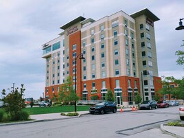 A multi-story hotel with a brick facade, large windows, and a flat roof.
