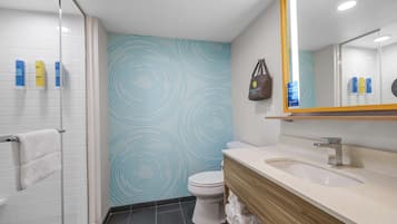 A modern bathroom with a shower, toilet, and vanity.
