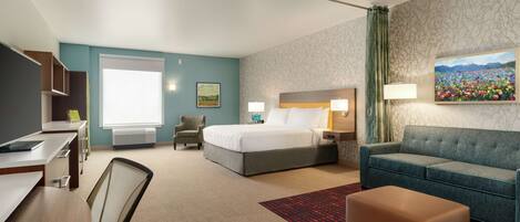 A hotel room with a bed, a desk, a chair, a sofa, and a painting on the wall.