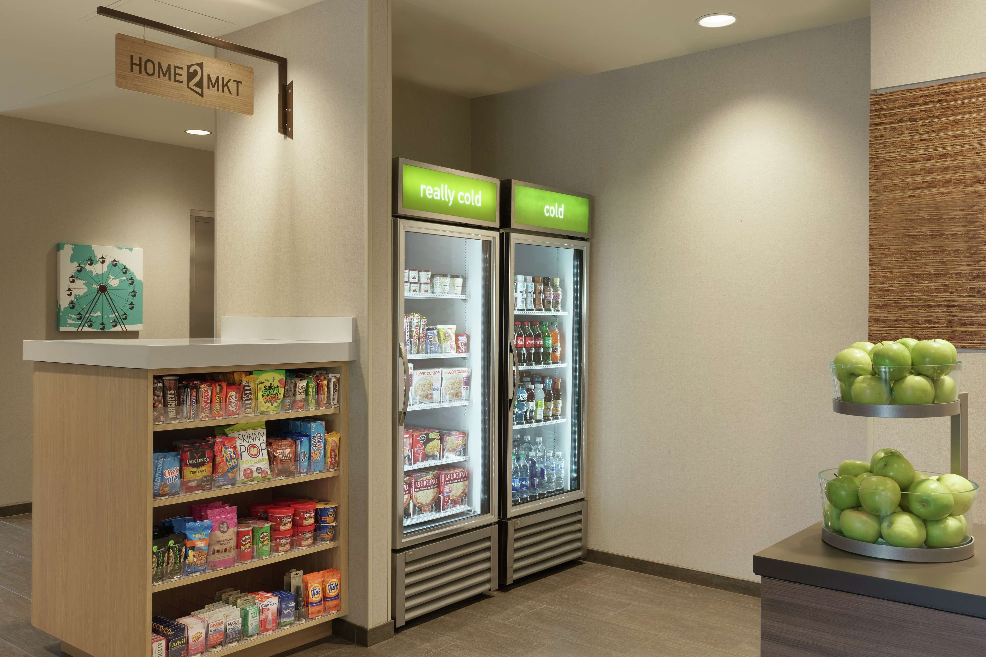 A kitchenette area with a sign reading "HOME2MKT" and two refrigerators labeled "really cold" and "cold".