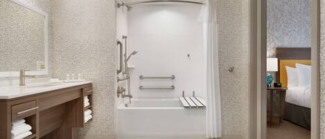 A modern bathroom with a bathtub, shower, and vanity.