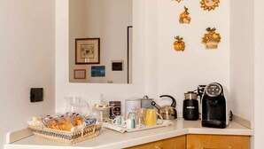 Una encimera de cocina con cafetera, hervidor y varios utensilios.