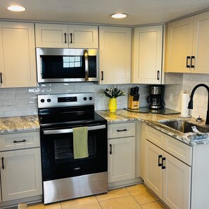 A kitchen with a stainless steel oven, microwave, and coffee maker. - The Monterey offers this view in 45 sec (Redington Shores)
