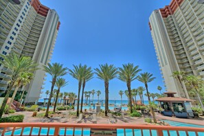 A resort pool area with palm trees, a sign prohibiting diving, and a view of the ocean. - Ground Floor Corner Unit | 2 Parking Spots (Panama City Beach)