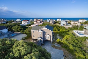 A residential area with houses, a swimming pool, and a view of the ocean.