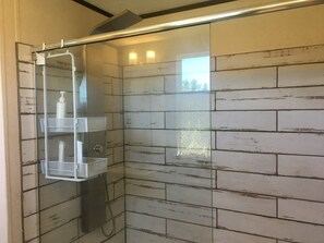 Een bad/douchecombinatie, een haardroger, handdoeken, zeep