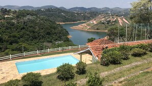 Una piscina con vistas a un lago y colinas circundantes.