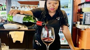 A person pouring a drink into a glass.