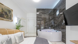 Une salle de bain moderne avec une baignoire sur pieds, des toilettes blanches et un espace douche.