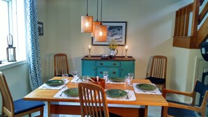 A dining room with a wooden table set for four, chairs, a teal cabinet, and pendant lights. - Wentworth Townhouse - Golf, Hike, Water Falls, Stoy Land!! (Jackson)