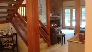 A staircase with wooden railings leading to a living room with a fireplace, a coffee table, and a small table with a candle. - Wentworth Townhouse - Golf, Hike, Water Falls, Stoy Land!! (Jackson)