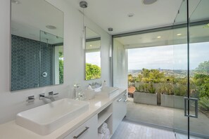 Een bad/douchecombinatie, een haardroger, handdoeken, zeep