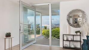 A modern interior with a sliding glass door leading to a balcony with a city view. - Single Level Home with 2 Primary Bedrooms, Views and Spa in La Jolla Hills (La Jolla)