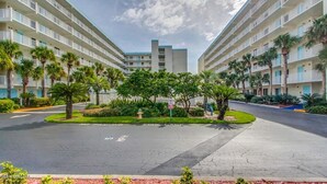A hotel with a central courtyard, multiple floors, and a parking area. - BEAUTIFUL DIRECT OCEANFRONT VIEW NOW RENTING FALL-SPRING WATCH ROCKET LAUNCHES! (Cocoa Beach)