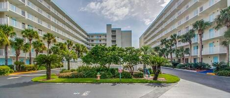 A hotel with a central courtyard, multiple floors, and a parking area.