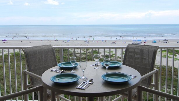 A table set for two with a view of the beach. - BEAUTIFUL DIRECT OCEANFRONT VIEW NOW RENTING FALL-SPRING WATCH ROCKET LAUNCHES! (Cocoa Beach)