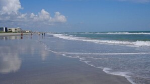 A beach with a clear sky and calm sea. - BEAUTIFUL DIRECT OCEANFRONT VIEW NOW RENTING FALL-SPRING WATCH ROCKET LAUNCHES! (Cocoa Beach)