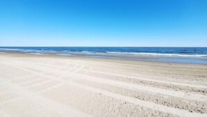Une plage avec un ciel dégagé et une mer calme.
