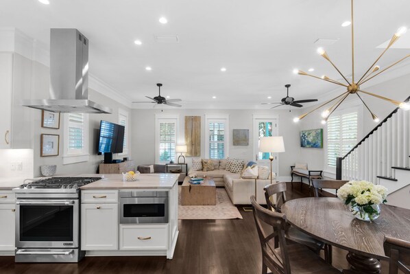 Une cuisine moderne équipée d’une cuisinière, d’un four et d’un coin repas avec une table et des chaises.