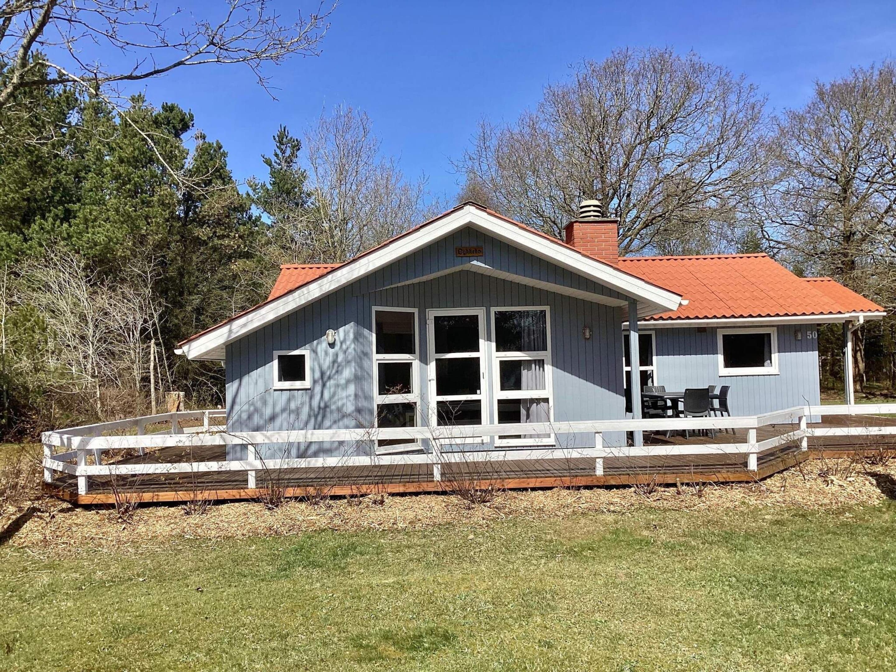 A two-story building with a covered porch and a fenced deck.