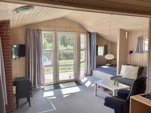 Una habitación acogedora con chimenea, televisor, sofá y mesa de centro.