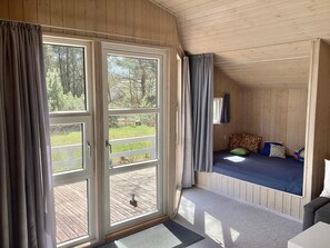 A room with a bed, a window, and a view of a deck. - Holiday Home in NÃ¸rre Nebel (Norre Nebel)