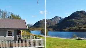Ein Haus mit Balkon mit Blick auf einen See und Berge.
