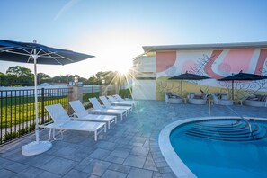 En säsongsöppen utomhuspool, parasoller och solstolar