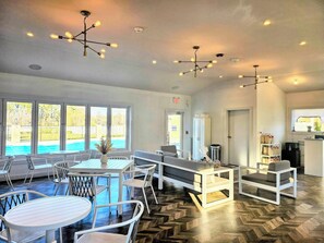 A modern lounge area with a pool view, white furniture, and contemporary lighting fixtures. - The Bentley Hotel Southampton (Southampton)