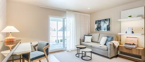 A modern living room with a glass dining table, a sofa, and a coffee table.